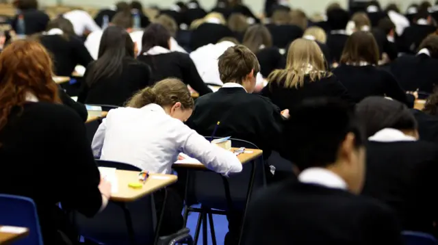 A child sits in an exam hall