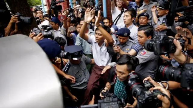 Reuters journalist Kyaw Soe Oo (C) is escorted out of the Insein township court in Yangon