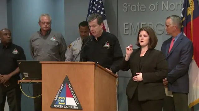 Roy Cooper speaking with emergency personnel