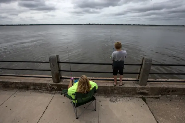 Mother and son fishing on pier