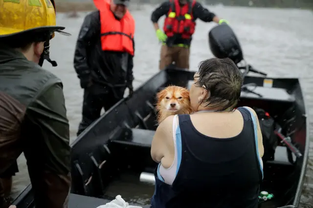 Rescue workers from Township No. 7 Fire Department and volunteers from the Civilian Crisis Response Team use a boat to rescue a woman and her dog from their flooded home during Hurricane Florence September 14, 2018 in James City