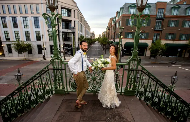 Newlyweds Kathryn and Anthony Palmisano stand on the steps of the Charleston City Market in a deserted downtown