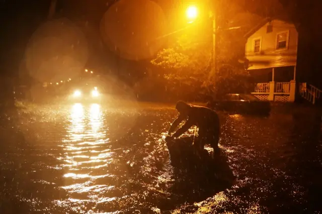 Man in flooded street at night