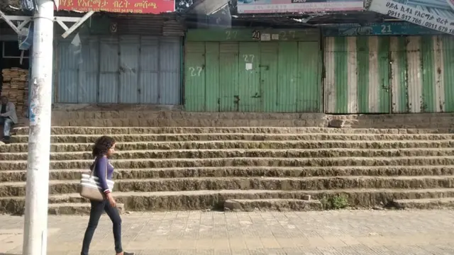 Woman walking past a shop