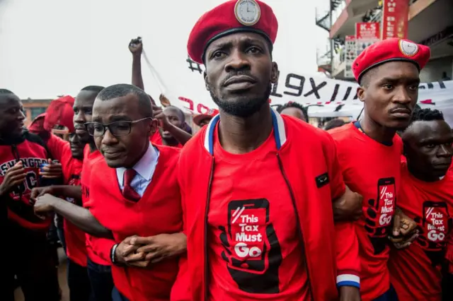 Musician turned politician Robert Kyagulanyi (C) is joined by other activists in Kampala on July 11, 2018 in Kampala during a demonstration to protest a controversial tax on the use of social media