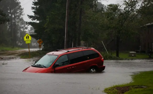 Abandoned minivan in floodwaters