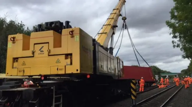 Crane removes derailed carriages