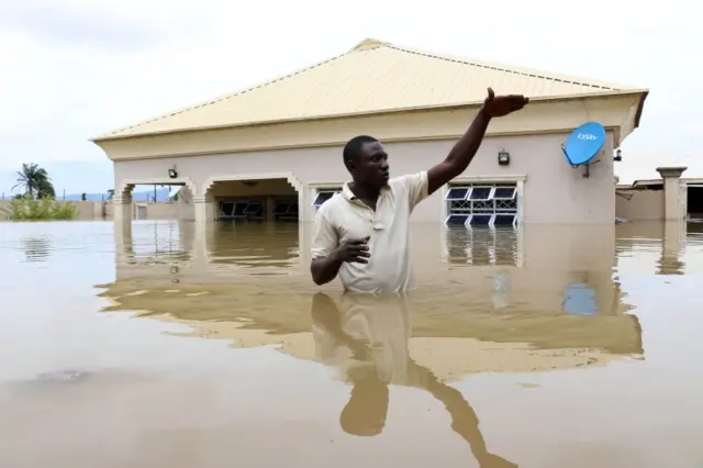 A man gestures next to his flooded house following heavy rain near the Nigerian town of Lokoja, in Kogi State, on September 14, 2018.