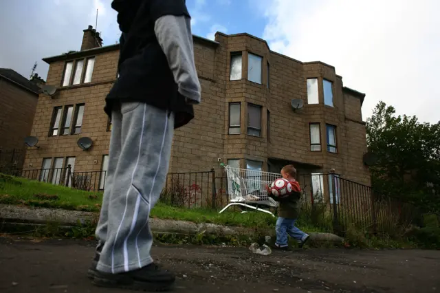 Kids playing outside dilapidated house