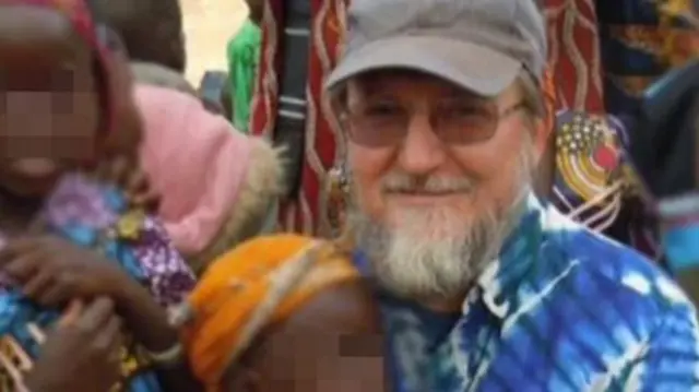 Father Pierluigi Maccalli seen with young children in Niger whose face have been pixellated