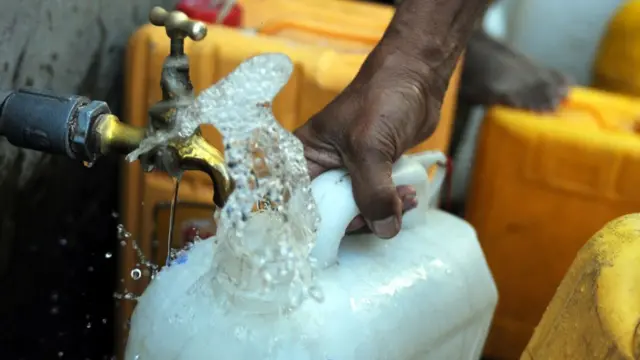 A man fills a jerry can with water