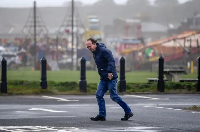 A member of the public struggles in high winds