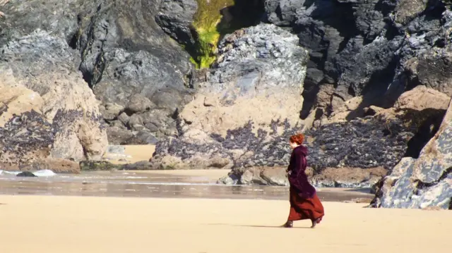 Eleanor Tomlinson walking on beach