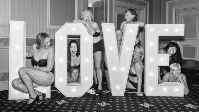 Dare to Bare group posing with giant 'LOVE' letters