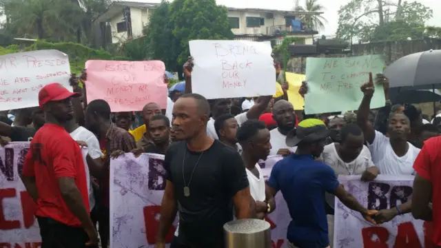 Protesters hold signs in Monrovia