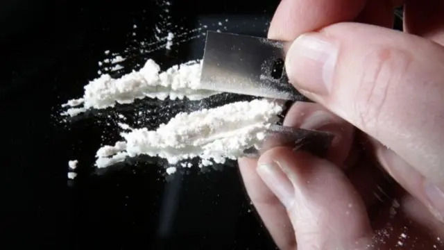 Cocaine or other drugs cut with razor blade on mirror