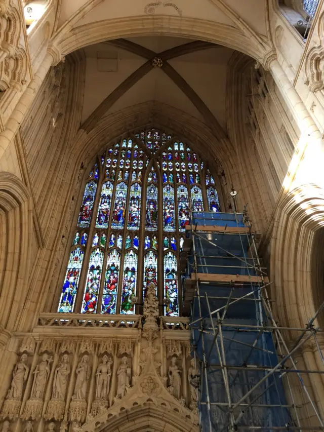 Scaffolding next to stained glass window