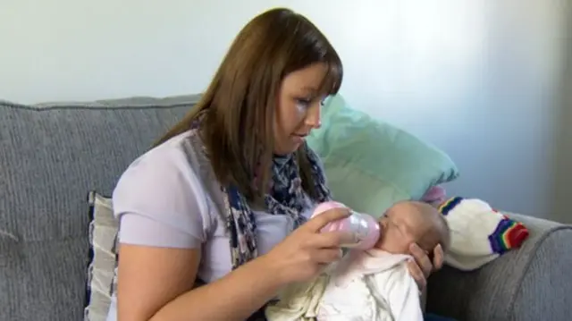 Mum feeds her baby with a bottle