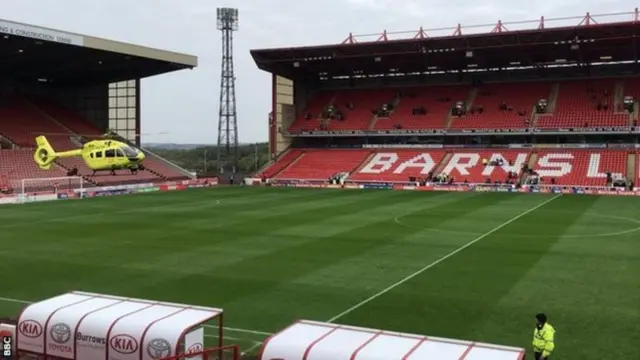 A helicopter lands on the pitch