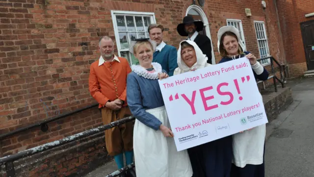 People in pilgrim dress with National Lottery grant board