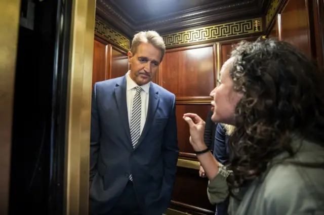 A woman who said she is a survivor of a sexual assault confronts Republican Senator from Arizona Jeff Flake (L) in an elevator