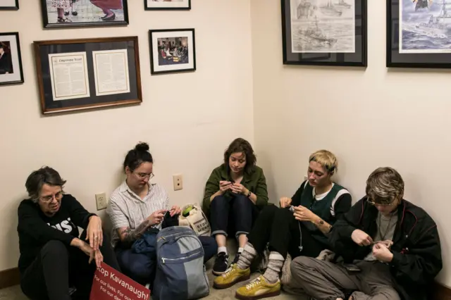 Women participate in a sit-in, some of them crocheting, in Susan Collins' office in Maine