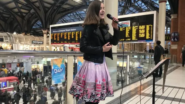 Girl singing at train station