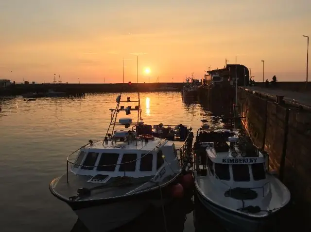 Boats moored in Bridlington with beautiful sunrise behind