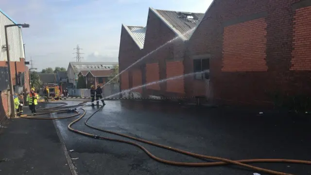 Fire crews spraying factory unit