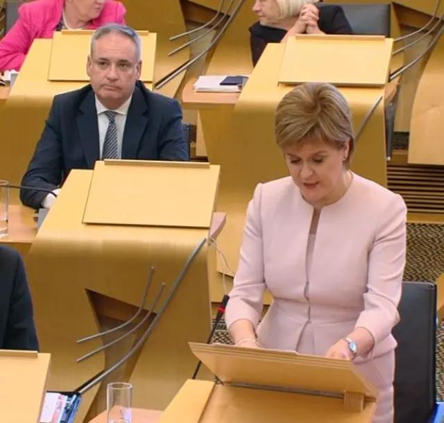 Richard Lochhead sitting behind Nicola Sturgeon