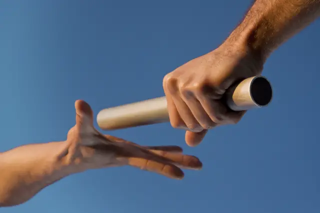 People exchanging a baton