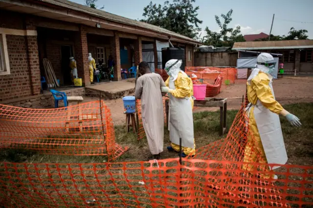 Medical workers lead a man with suspected Ebola into the unconfirmed Ebola patients ward run by The Alliance for International Medical Action (ALIMA) on August 12, 2018, in Beni