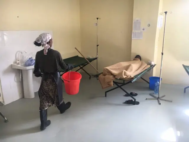 Woman carrying a bucket in hospital