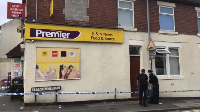 Police officers outside K&M shop