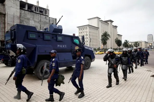 Congolese policemen walk near Congo"s Independent National Electoral Commission (CENI) headquarters in Kinshasa, Democratic Republic of Congo, January 10, 2019.