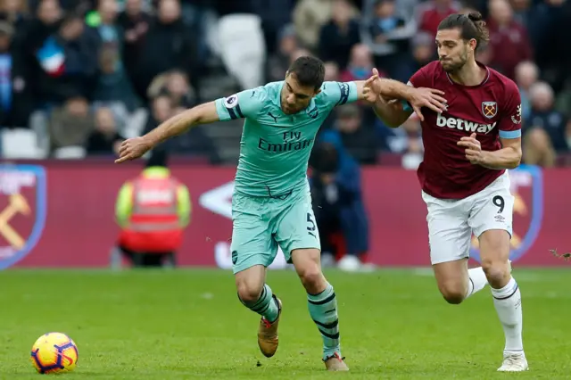 Andy Carroll competes with Sokratis Papastathopoulos