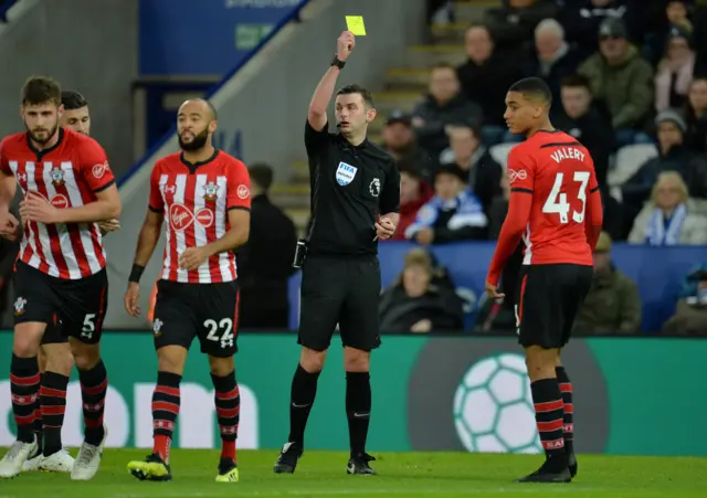 Michael Oliver shows a yellow card