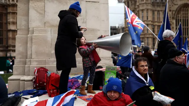 A young girl shouts through a loud hailer outside the House of Commons