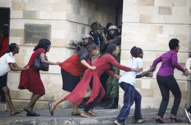 People running with army gunmen behind them