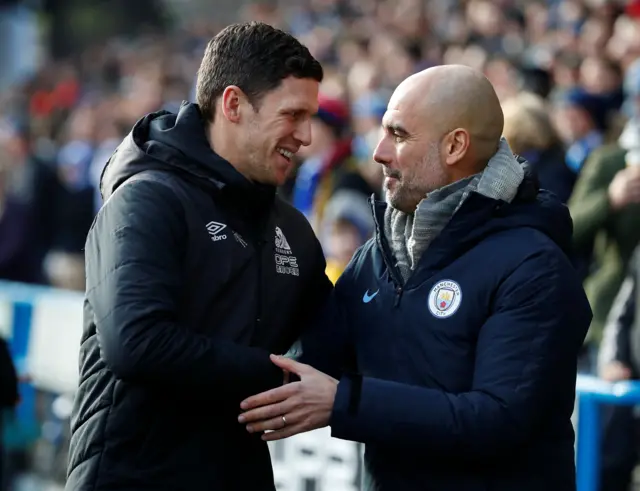 Manchester City manager Pep Guardiola shakes hands with Huddersfield Town caretaker manager Mark Hudson