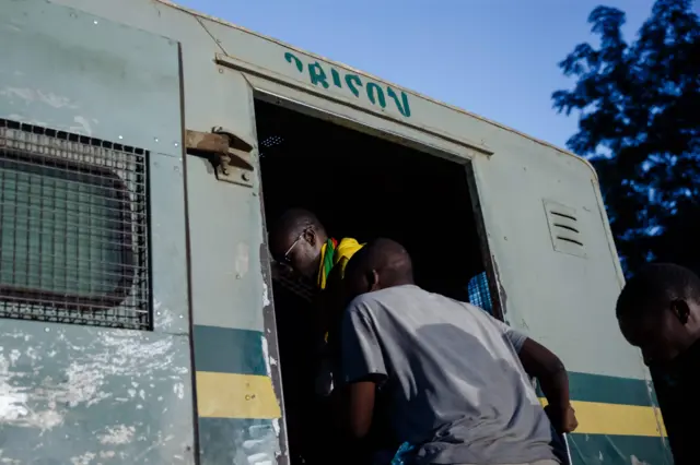 Evan Mawarire, left, in prison van