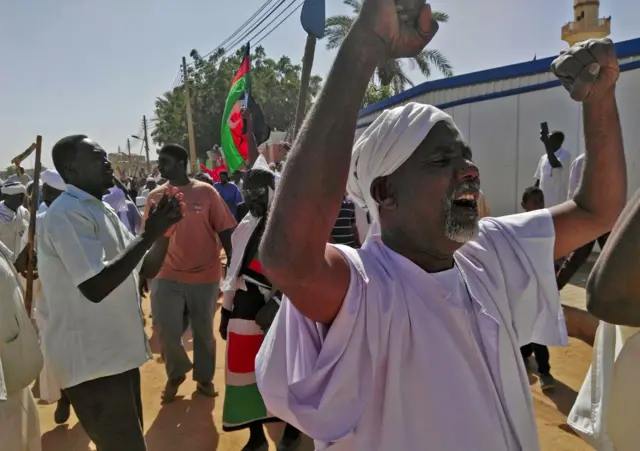 Sudanese men shout slogans during an anti-government protest f