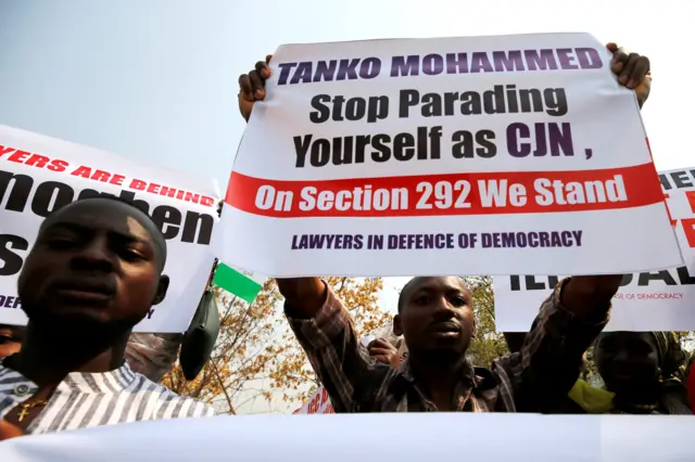 People hold banners during a protest over the suspension of the chief justice of Nigeria (CJN), Walter Onnoghen, in Abuja, Nigeria January 28, 2019.