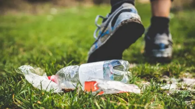 A person steps over litter