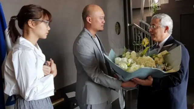 Pichayapa Natha and band manager Nataphol Pavaravadhana present a bouquet to Israeli ambassasor Meir Shlomo in Bangkok