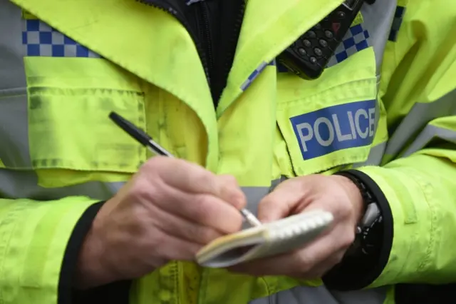 Police officer writing in notebook