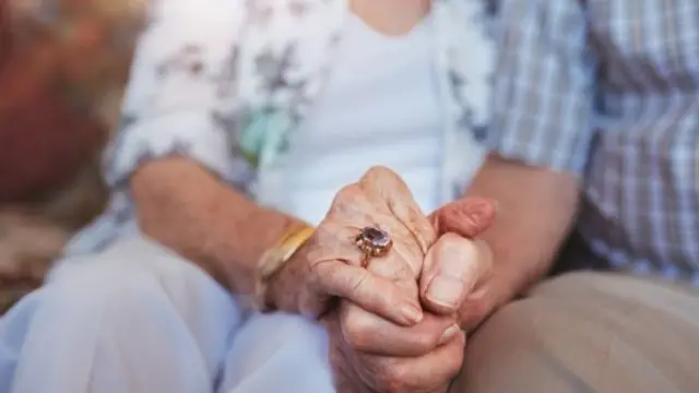 Older people holding hands