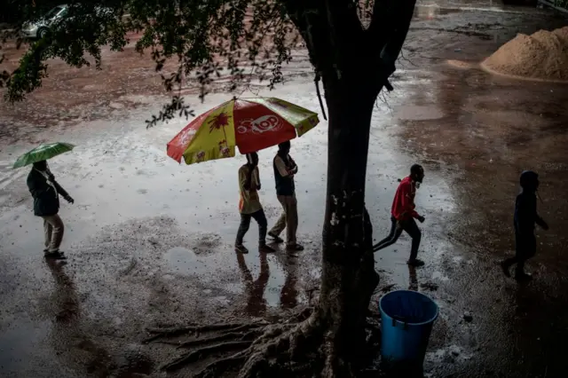 Voters arrive under torrential rain to vote at the Monsignor Moke school complex in Victoire district during general elections in Kinshasa on December 30, 2018.