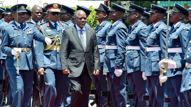 President John Magufuli walks past troops at the State House