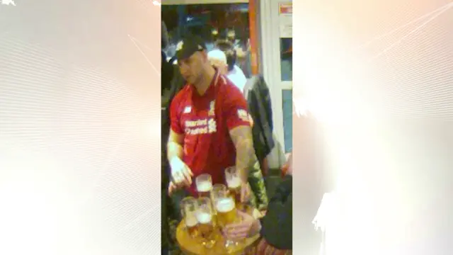 A man wearing a Liverpool shirt